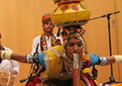 An artist of Rajasthani Cultural Group lifting a Rs 100 by her mouth from ground with three pots on her head at Canberra